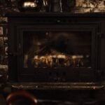 A warm and inviting vintage fireplace against a rustic brick wall, perfect for cozy winter settings.